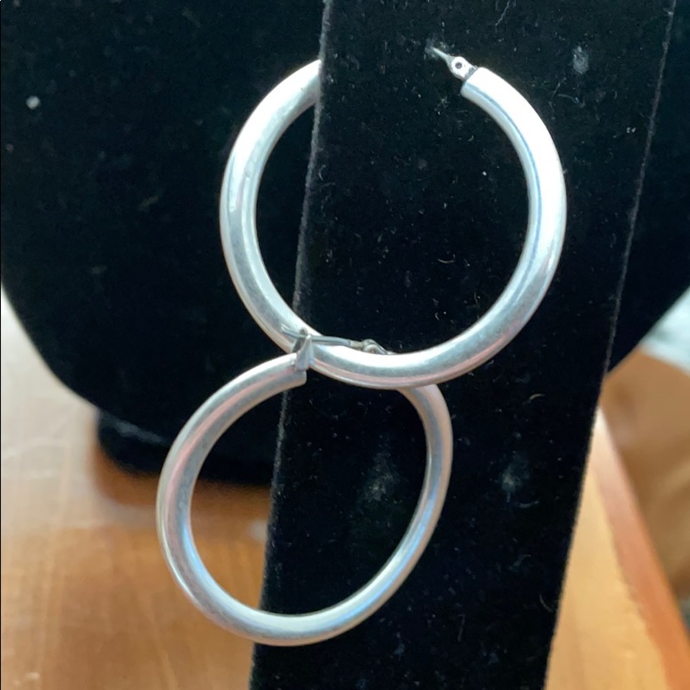 Silver tone hoop pierced earrings.